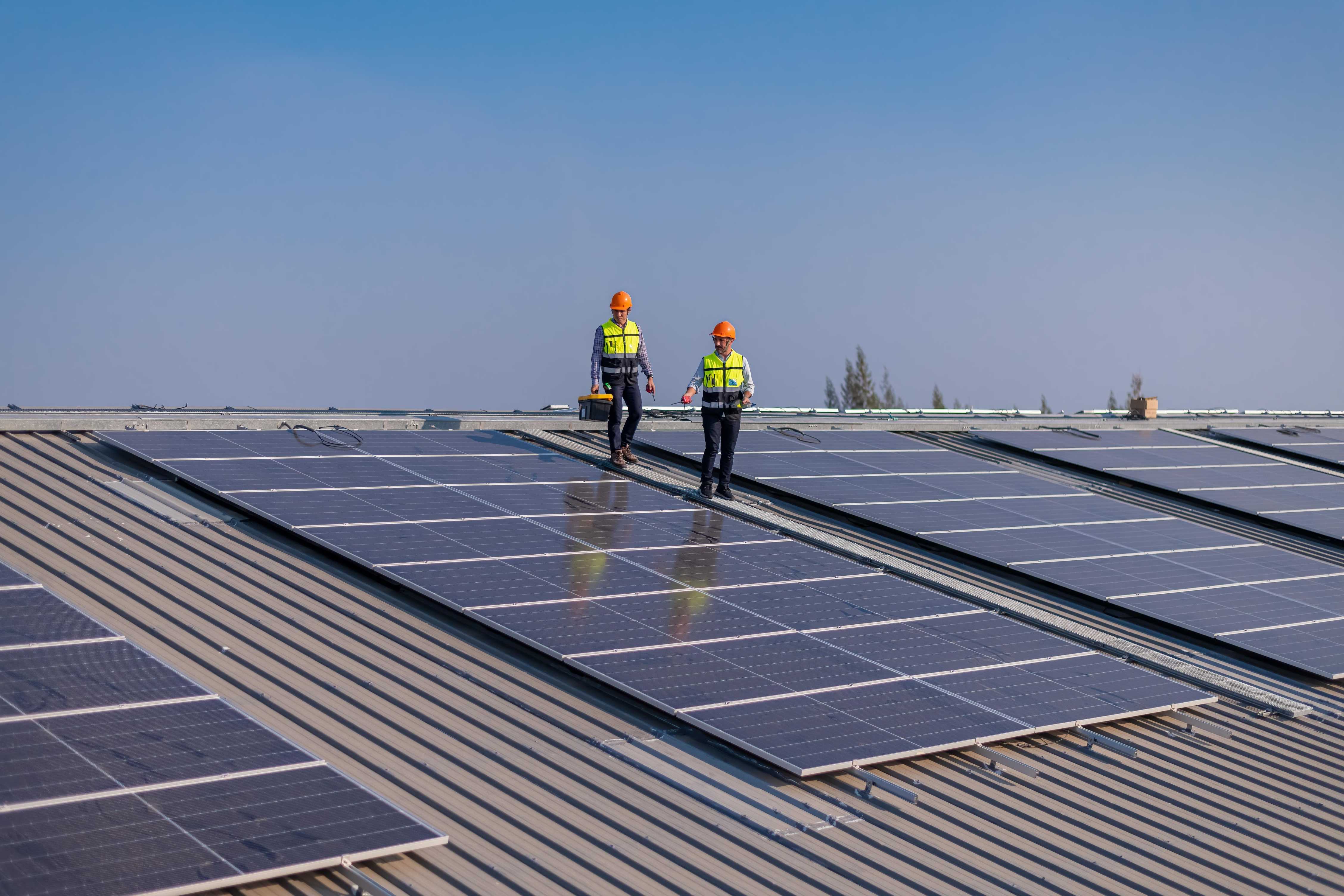 engineers walking on roof and checking solar panels