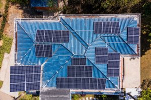 solar panels on a roof of a big house with blue roofing