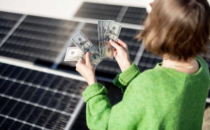 woman on green sweater counting dollar bills