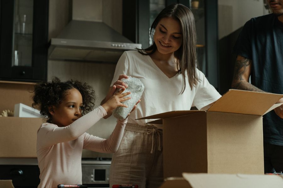family unpacking boxes in their new Texas home with solar panels