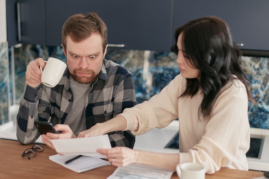 Texas couple reviewing a rising electricity bill at their kitchen table